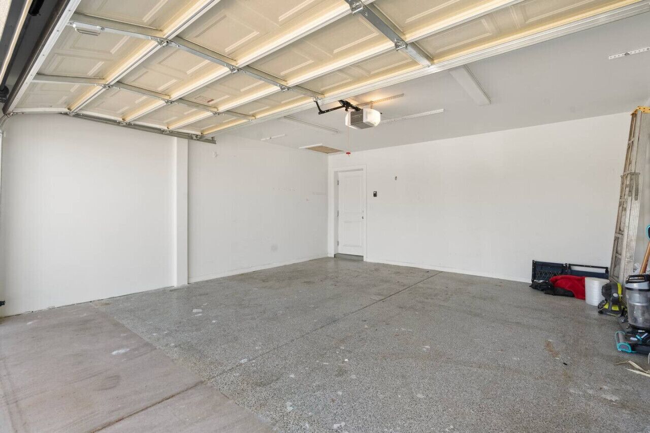 A spacious, unfinished garage with a concrete floor and a metal roof.