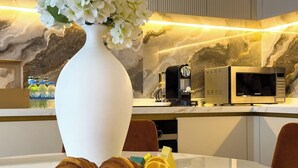 Et morgenbord med croissanter, et citronskive og en vase med blomster på et bord.
