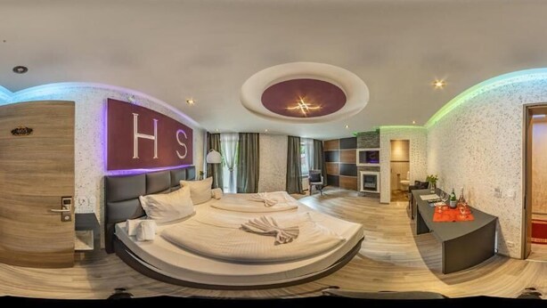 Een moderne hotelkamer met een groot bed, een bureau en een zithoek.
