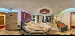 Une chambre d’hôtel moderne dotée d’un grand lit, d’un bureau et d’un coin salon.