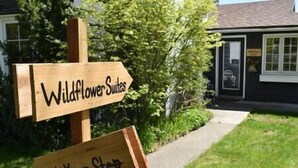 A wooden sign with "Wildflower Suites" and "Watch Your Step" written on it. - Wildflower Suites North (Garfield)