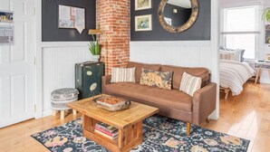 A cozy living room with a brown sofa, a wooden coffee table, and a patterned rug.