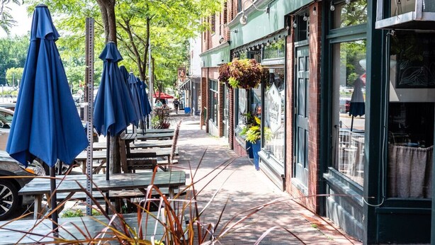 A sidewalk cafe with outdoor seating and umbrellas. - Bohemian Penthouse | 1min Walk Restaurants + Shops (Winooski)