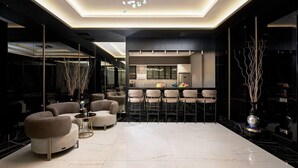 Un interior moderno con una zona de bar, asientos y una cocina.