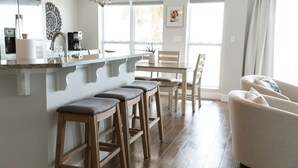Eine moderne Küche mit Holzhockern, einem Esstisch und einer Couch.