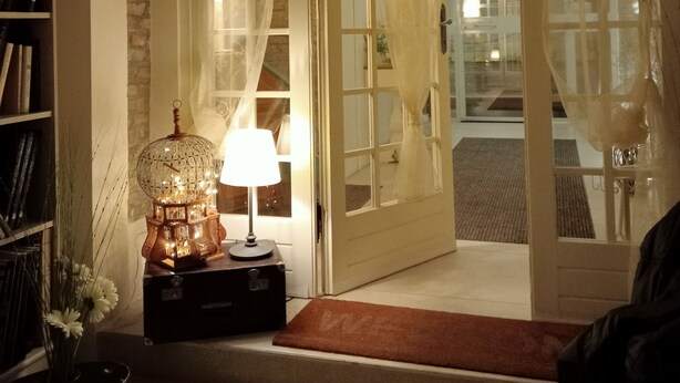 An open doorway with sheer curtains, a lamp on a table, and a bookshelf. - AriediParma - Rooms & Apartments (Parma)