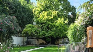 A wooden table with a bottle of champagne and two glasses on a patio. - AriediParma - Rooms & Apartments (Parma)