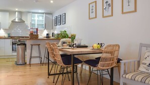 Une cuisine moderne dotée d’un îlot central, de tabourets de bar et d’une table à manger avec des chaises.