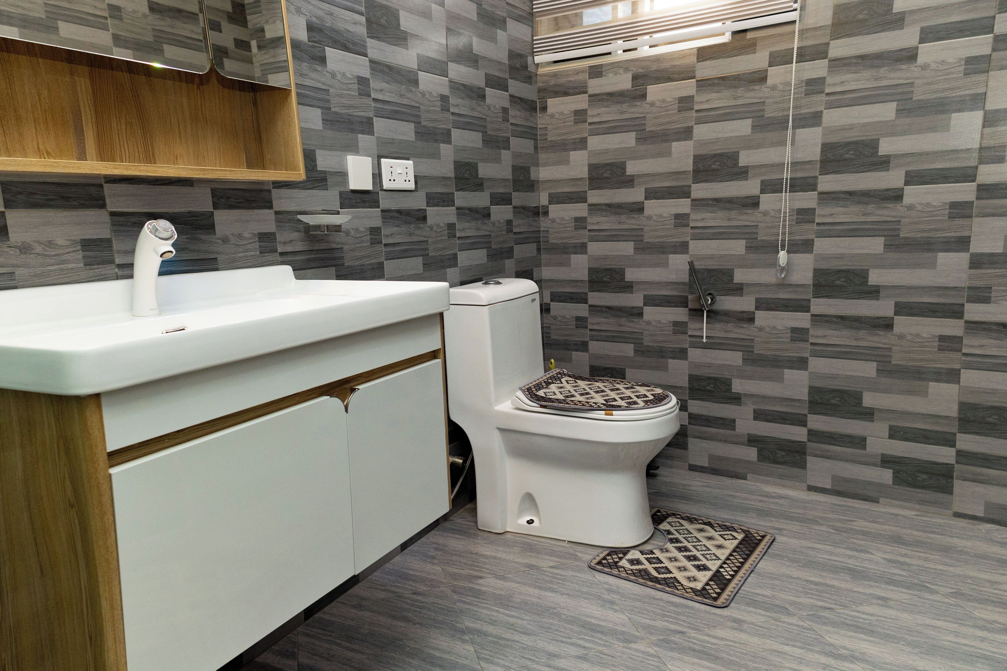 Un baño moderno con lavamanos, inodoro y ducha blancos.