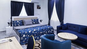 A modern bedroom with a bed, a sofa, a round coffee table, and a desk with a telephone. - Firnic Luxurious Private Hotel (Kwabenya)
