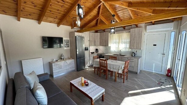 Un grand espace de vie comprenant un canapé, une table à manger et une cuisine à l’arrière-plan.