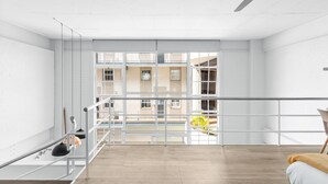 Une pièce spacieuse dotée d’un balcon, de grandes fenêtres et d’un ventilateur de plafond.