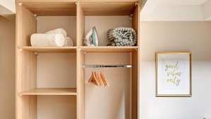 A wooden storage unit with shelves, a hanging rack, and a framed motivational quote on the wall. - TheBlueStay 39 – Cosy Apartment Buttes-Chaumont (Paris)