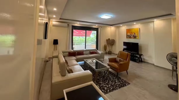 A modern living room with a sofa, coffee table, and TV. - Cosy F3 in the center of Dakar (Dakar)