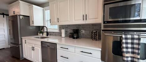 Bright, fully stocked kitchen with stainless steel appliances and everything you need for cooking during your stay.