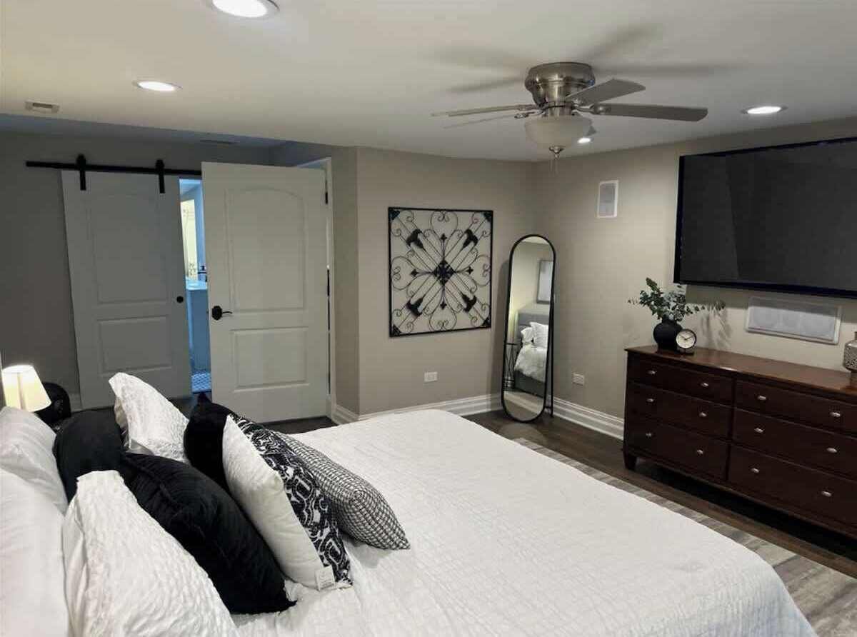 {MASTER BEDROOM} Refresh in the master bedroom with a plush king bed, 65" smart TV, dresser, and closet. The ensuite bathroom features a relaxing soaking tub and a stand-up shower for ultimate comfort.