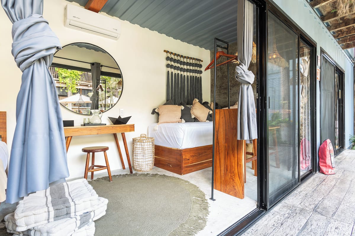 Une chambre à coucher avec un lit, un bureau et une grande fenêtre.
