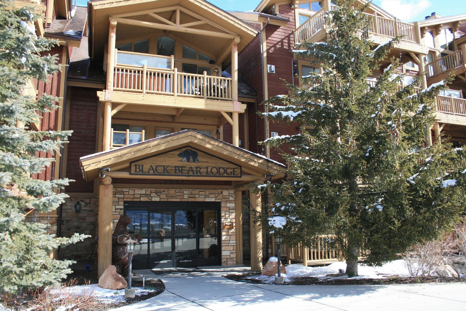 A multi-story lodge with a prominent entrance, balconies, and a sign reading 'BLACK BEAR LODGE'.