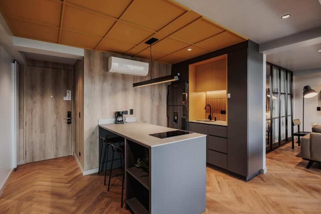 Una cocina moderna con una isla central, electrodomésticos integrados y techo de madera.