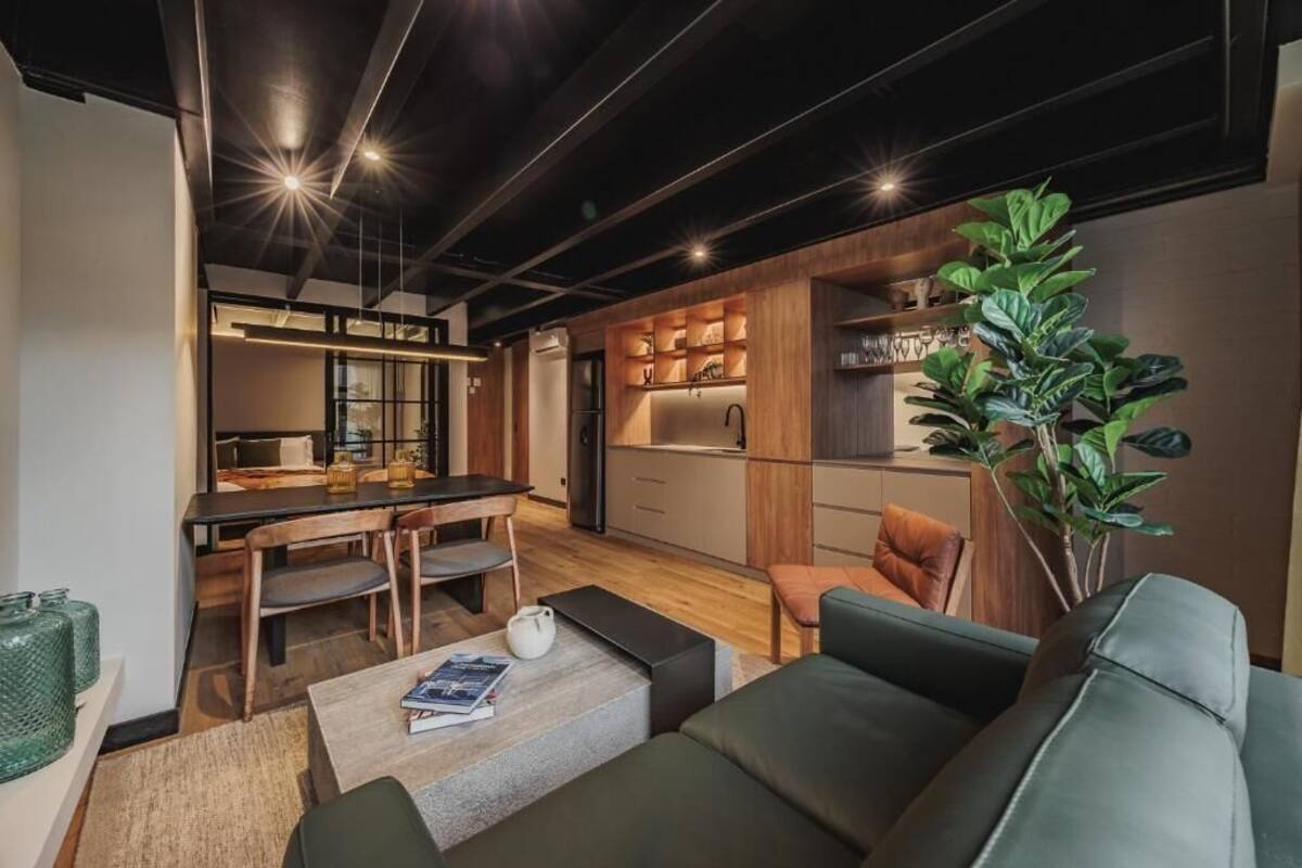 Ein modernes Wohnzimmer mit Sofa, Couchtisch und einem Essbereich mit Tisch und Stühlen.