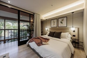 A modern hotel room with a large bed, a view of the outdoors, and two framed pictures on the wall. - H10 Provenza (Medellín)