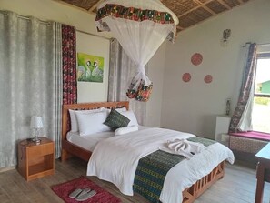 A bedroom with a bed, nightstand, and a window with curtains. - ngirisi hill silverback  lodge-bwindi (Bwindi)