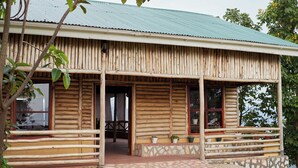A rustic log cabin with a porch and stone foundation. - ngirisi hill silverback  lodge-bwindi (Bwindi)