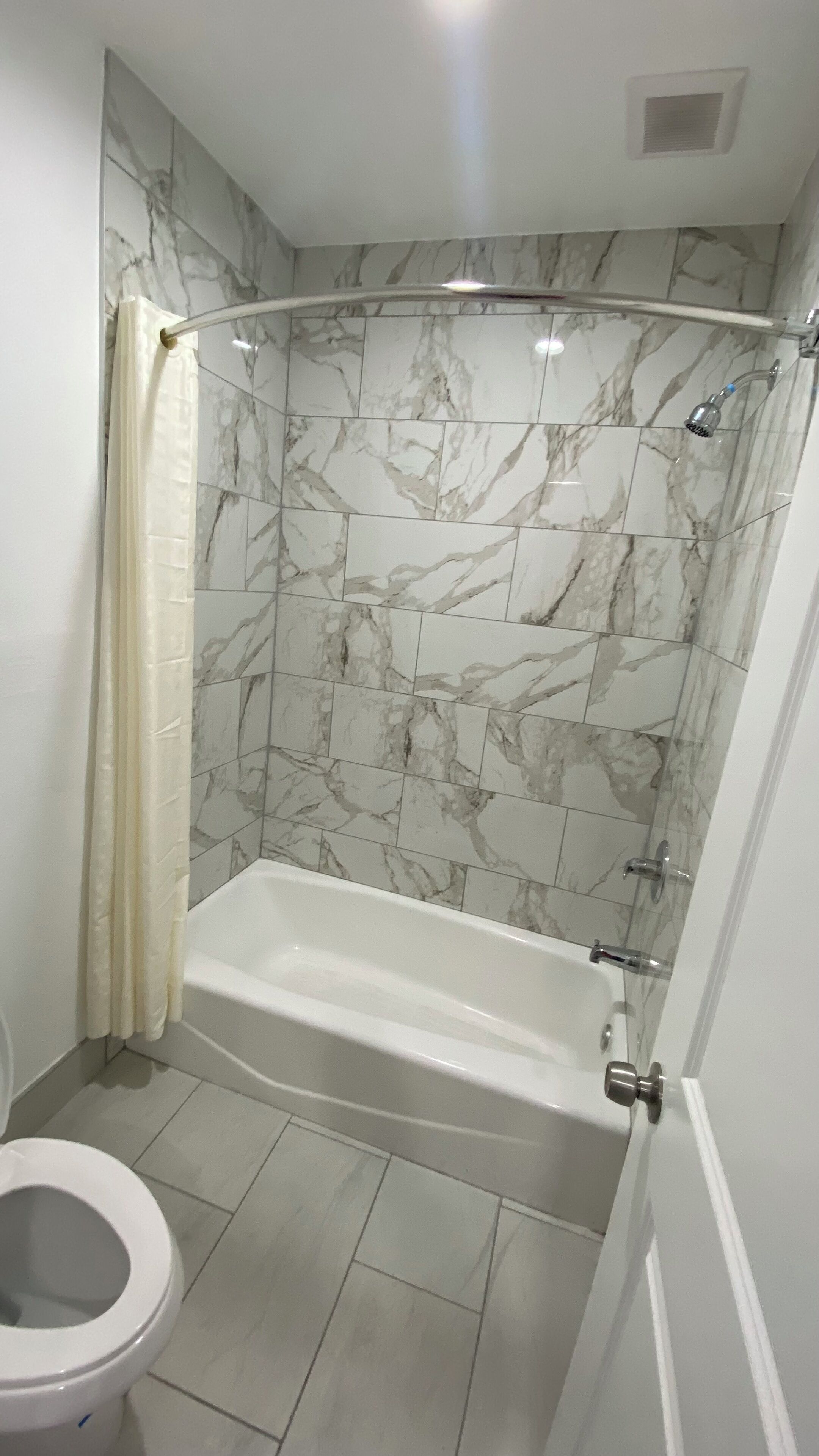 A bathroom with a shower enclosure, a bathtub, and a toilet.