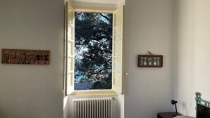 Una stanza con una finestra, un termosifone e due elementi fissati al muro.