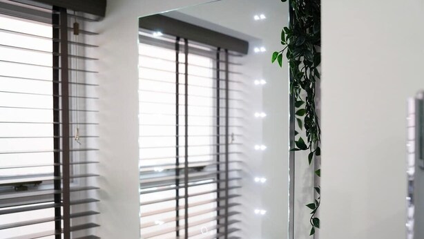 Una habitación moderna con un gran ventanal, persianas y aire acondicionado instalado en la pared.
