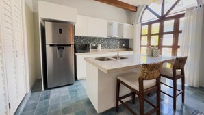 A modern kitchen with a built-in refrigerator, microwave, and sink. There is a large window providing natural light and a view of the outside. - Centro Historico on the Malecon Boardwalk (Mazatlan)