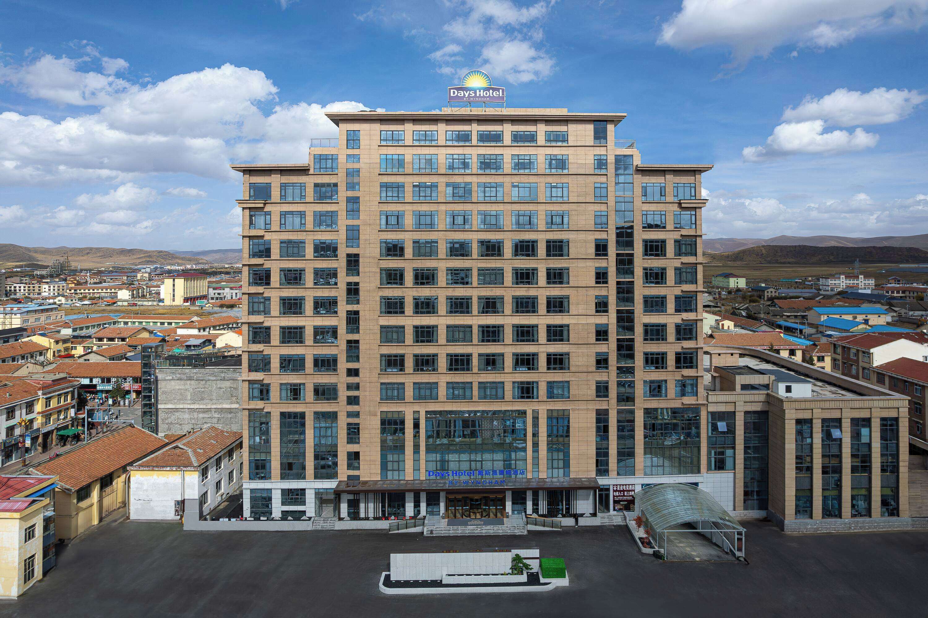 Edificio de un Days Hotel con fachada de vidrio moderna, varios pisos y techo plano.