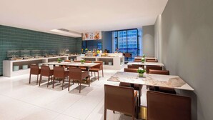 A modern restaurant with a long counter, multiple tables, and chairs. - Days Hotel By Wyndham Taizhou Sanmen (Taizhou)