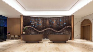 A modern lobby with two large tubs, a decorative wall, and a marble floor. - Days Hotel By Wyndham Taizhou Sanmen (Taizhou)