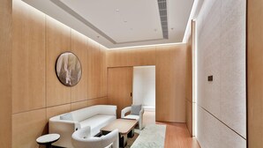 A modern room with a sofa, armchairs, a coffee table, and a round mirror. - Wyndham Garden Hangzhou Xixi (Hangzhou)