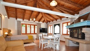 Una sala acogedora con un sofá, una mesa de comedor con sillas, un televisor y una chimenea.