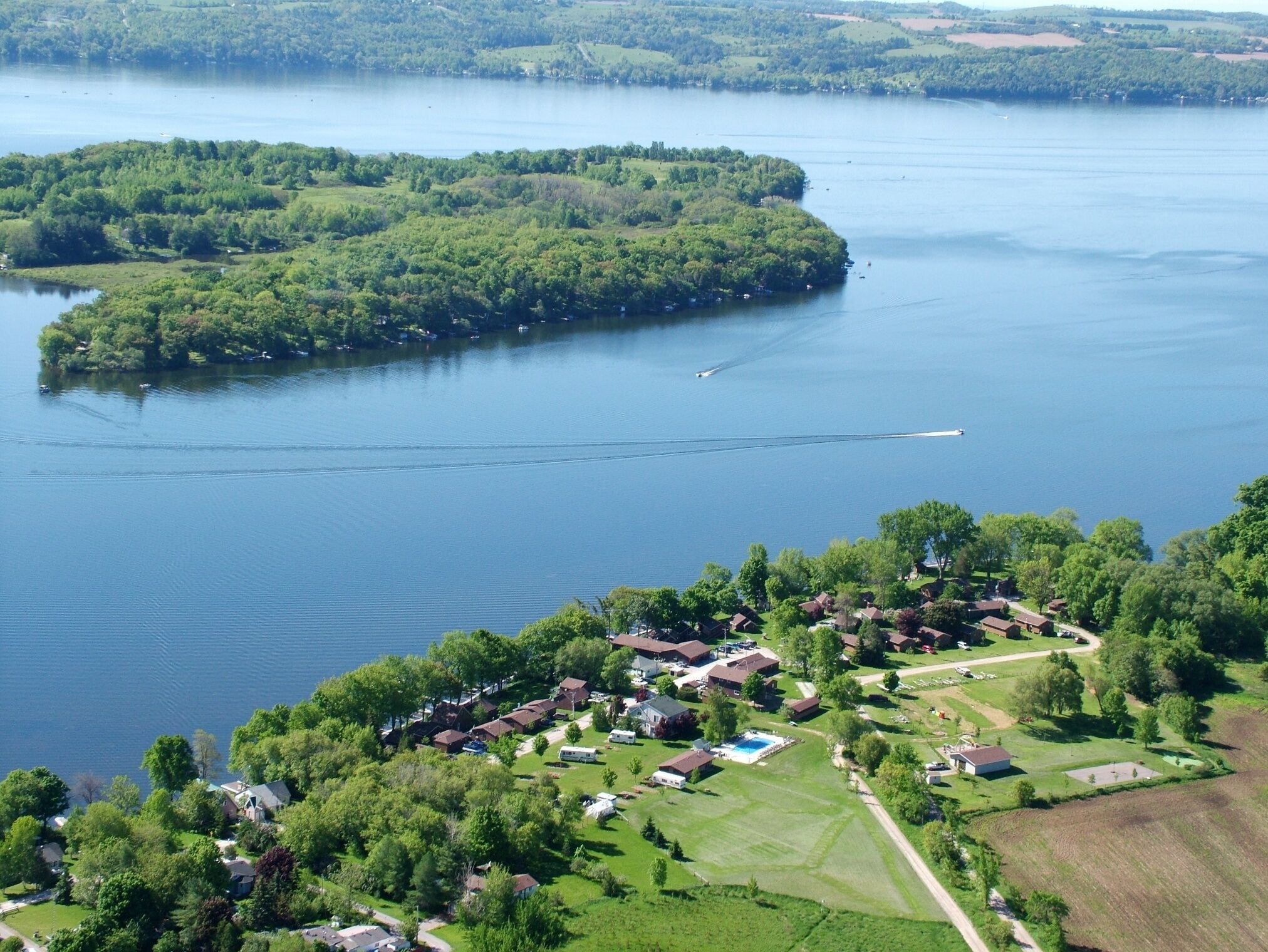 Vue aérienne d’une communauté riveraine, avec des maisons, une piscine et une rampe d’accès pour bateaux.