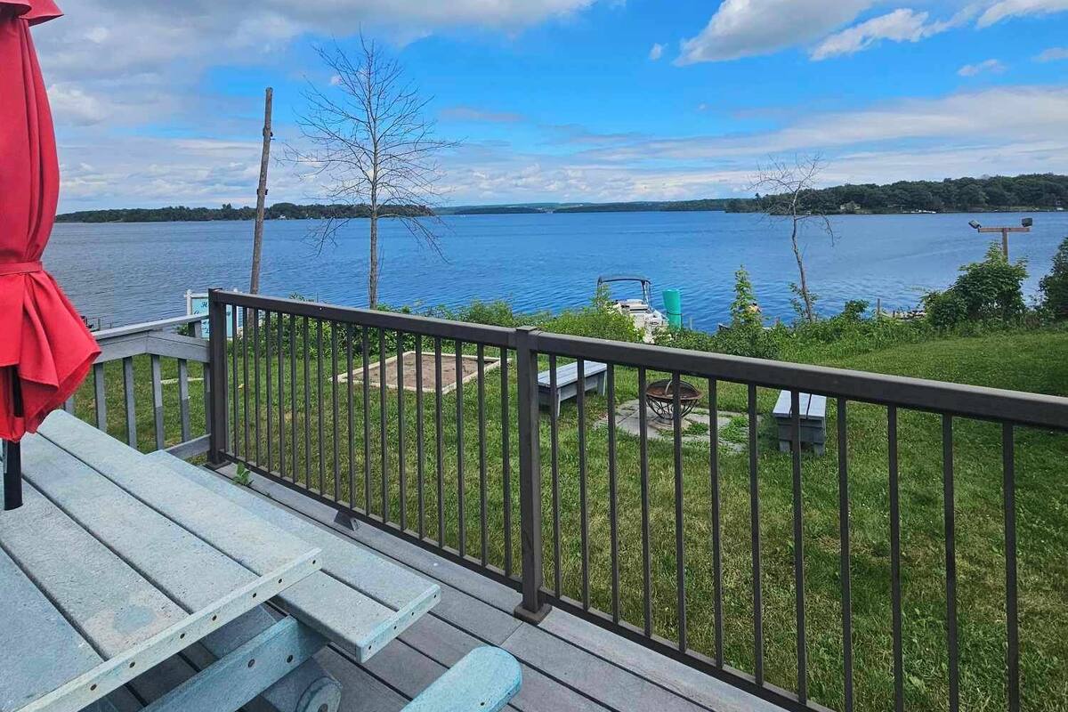A deck with a view of a lake and distant shoreline.