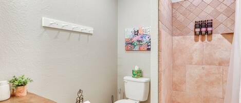 A bathroom with a toilet, sink, and shower area.