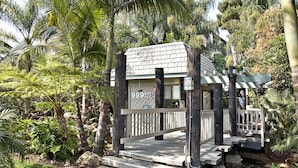 Eine kleine Holzhütte mit einem Schild, auf dem '999 North Pacific' steht, inmitten eines üppigen Gartens.