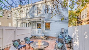A patio with outdoor seating, a fire pit, and a covered porch.