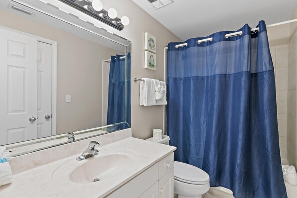 A bathroom with a white sink, mirror, and toilet. - Majestic Sun 1001a (Miramar Beach)