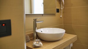 Une salle de bain avec un lavabo blanc, un miroir et un porte-serviettes.