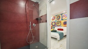 A modern bathroom with a glass-enclosed shower, a white sink, and a colorful abstract painting on the wall. - Becoloured Circles Suite. Where it is possible to dream among the masterpieces of art. (Napoli)