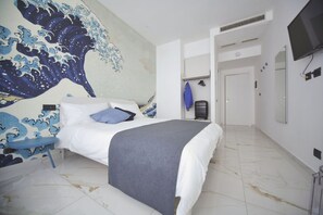 A bedroom with a bed, a wall mural, a TV, and a door leading to another room.