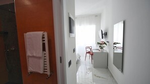 A modern bathroom with a white sink, a red chair, and a large mirror. - Venice Suite. Becoloured, where it is possible to dream among art masterpieces. (Napoli)
