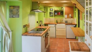 A compact kitchen with a central island, built-in appliances, and a small dining area.