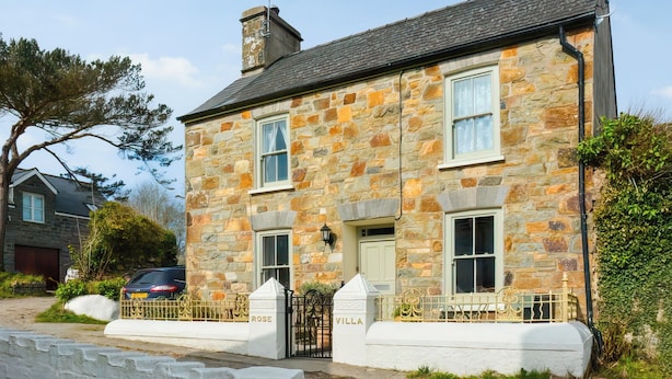A stone building with a traditional design, featuring two windows and a door.