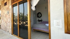 A room with a bed, a mirror, and a door leading outside. - Gloria del mar  (Santa Maria Colotepec)