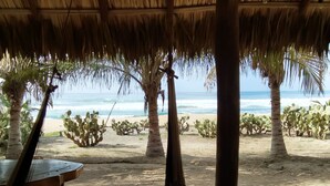 A beachside hut with a thatched roof, wooden tables, and a view of the ocean. - Gloria del mar  (Santa Maria Colotepec)